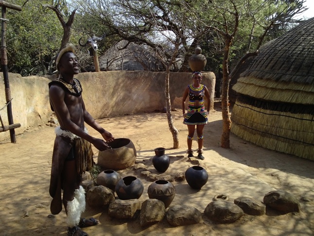 Zulu girl demostrates how to carry a clay pot on her head during our Durban Day Tour to Shakaland